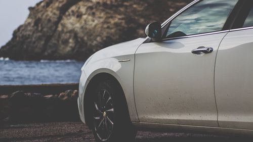 Vintage car on rock by sea