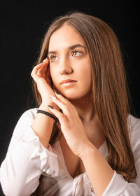 Portrait of a beautiful young woman over black background