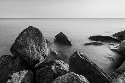 Scenic view of rocks in sea against sky