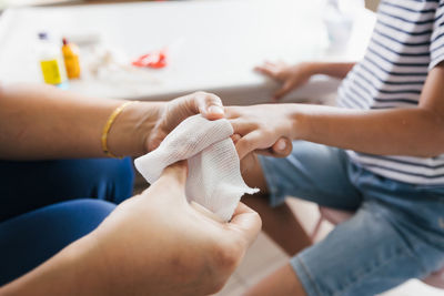 Parent helping her child perform first aid finger injury after she has been an accident.