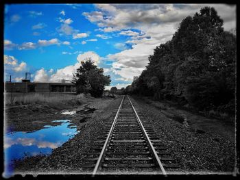 Railroad track against cloudy sky