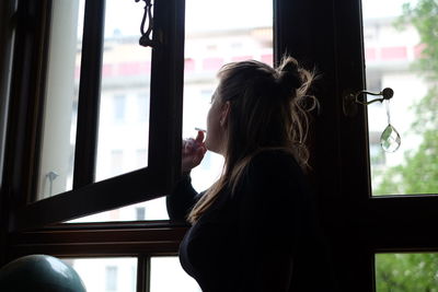 Thoughtful woman looking through window