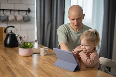 Side view of boy using digital tablet at home