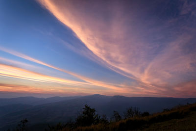 Scenic view of silhouette mountains against sky at sunset