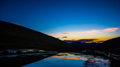 Scenic view of calm sea against mountain range