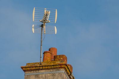 Low angle view of old windmill against clear blue sky