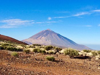 Scenic view of mountain against blue sky