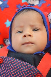 High angle portrait of cute baby boy lying on bed