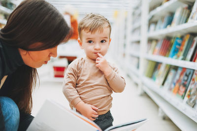 Young woman with baby boy in library