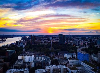 High angle view of buildings against cloudy sky during sunset