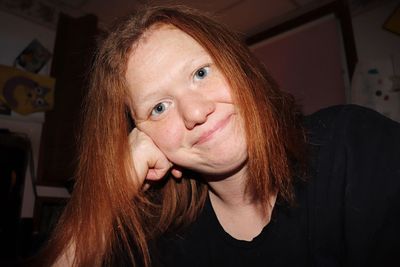 Close-up portrait of young woman sitting at home