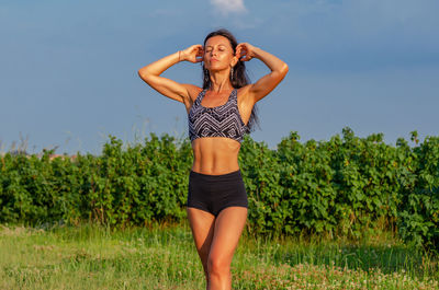 Full length of young woman standing on field