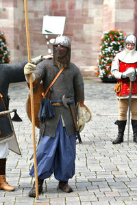 People in period costume standing on footpath knight tournament