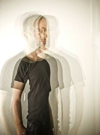 Multiple exposure image of man standing by wall