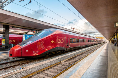 Train at railroad station in city against sky