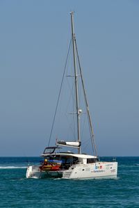 Sailboat sailing on sea against clear sky