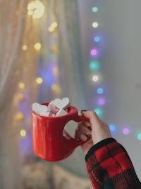 Cropped hand of woman drinking coffee with marshmallows.