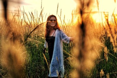 Portrait of smiling young woman standing on land