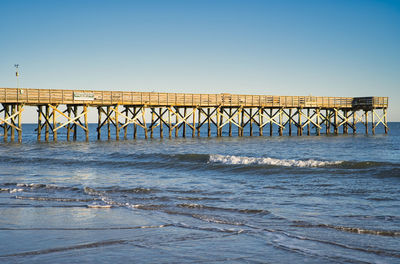 Bridge over sea against clear sky