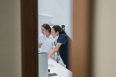 Side view of medical practitioners browsing data on modern computer while working in lab of modern hospital together