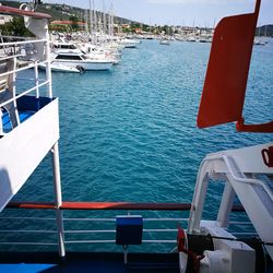 Boats moored at harbor against sky