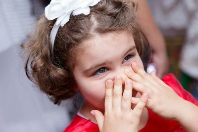 Close-up portrait of girl touching nose