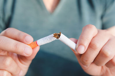 Close-up of hand holding cigarette