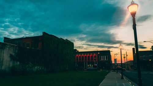 Street amidst buildings against sky at dusk