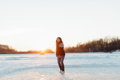 Smiling woman ice-skating on frozen lake