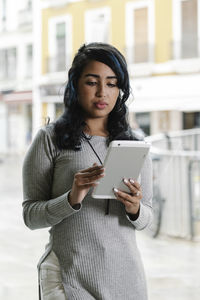 Young woman using mobile phone in city