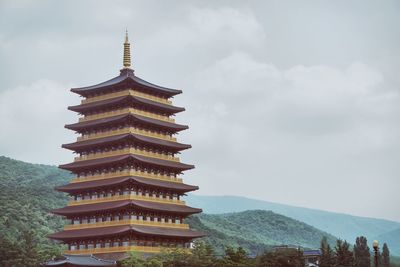 Temple by mountain with sky in background