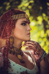 . gorgeous brunette bride  dressed outdoors in india.  bollywood dancer in sari and henna on hands