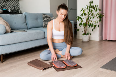 Athletic millennial woman with wooden sadhu board with nails or a fire board, a yoga desk 