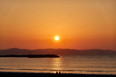 Scenic view of sea against orange sky