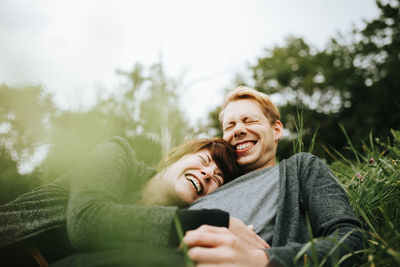 Portrait of smiling young woman using mobile phone outdoors