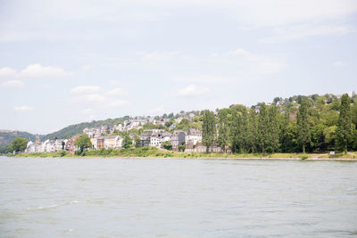 Scenic view of river by buildings against sky