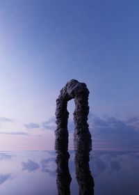 Arch reflecting on lake during sunset