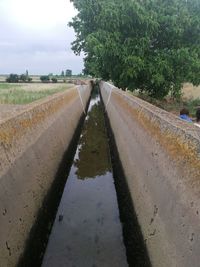 Surface level of road against sky during rainy season