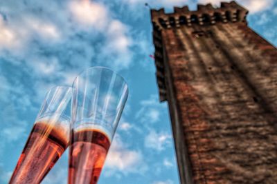 Low angle view of glass of building against sky