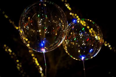 Low angle view of transparent balloons at night