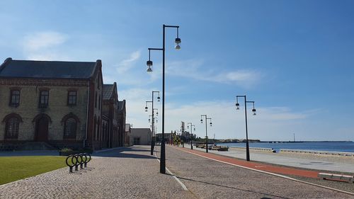 Street by sea against sky in city