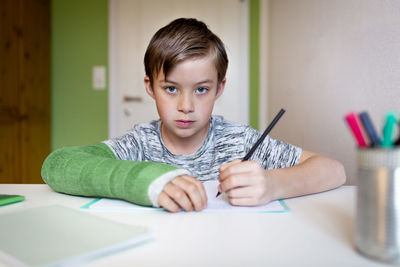 Portrait of boy sitting on table