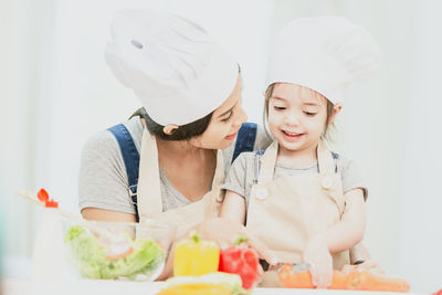 Full length of mother and daughter in kitchen