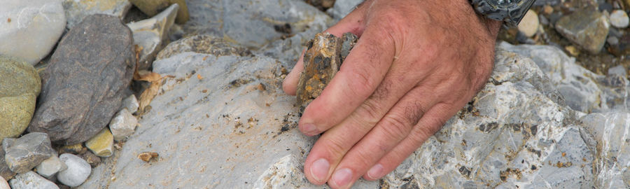 Cropped hand of man holding stone