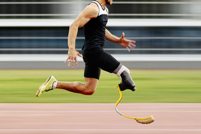 Full length of woman exercising on field