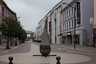 Street amidst buildings against sky in city