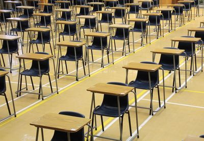 Empty chairs and tables in examination hall