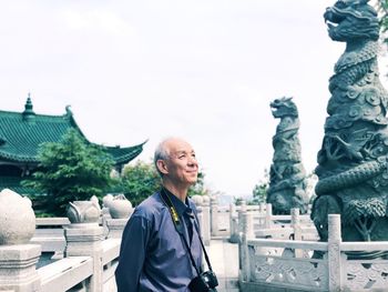 Full length of man sculpture outside building against clear sky