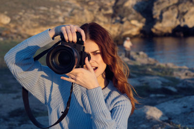 Portrait of young woman photographing camera