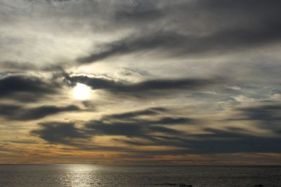 Scenic view of sea against cloudy sky at sunset